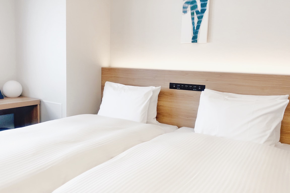 Habitación de hotel con dos camas blancas preparada para un descanso a medida profesional